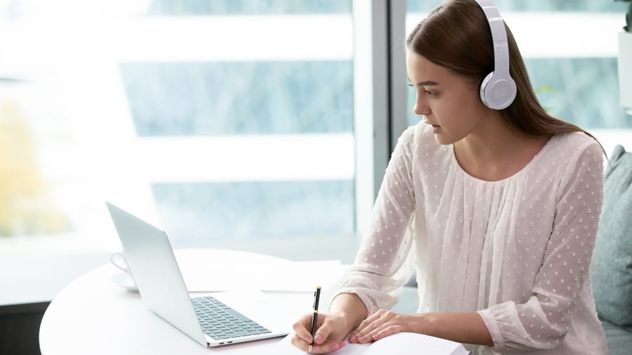 young-woman-headphones-taking-notes-computer